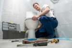 man repairing clogged toilet