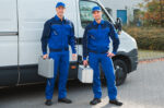 plumbers standing in front of a van