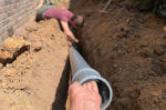 men repairing sewer line